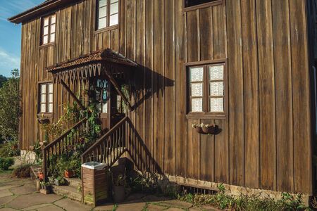 Bento Goncalves, Brazil - July 11, 2019. Decorated entrance with plants and stairs on the facade of charming wooden house near Bento Goncalves. A friendly country town famous for its wine production.のeditorial素材