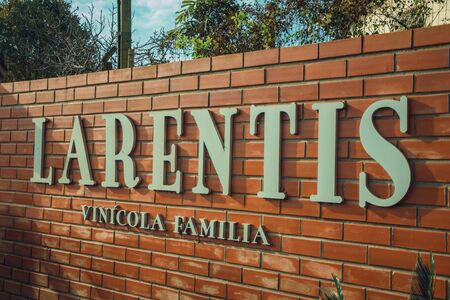 Bento Goncalves, Brazil - July 13, 2019. Outer bricks wall with the company sign of Larentis Winery, near Bento Goncalves. A friendly country town famous for its wine production.のeditorial素材