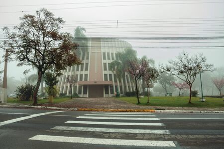 Bento Goncalves, Brazil - July 14, 2019. Modern style Saint Benedicts Church amidst lush garden on a foggy day in Bento Goncalves. A friendly country town famous for its wine production.のeditorial素材