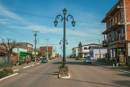 Cambara do Sul, Brazil - July 19, 2019. Flamboyant light poles and houses with store on the Getulio Vargas Avenue in Cambara do Sul. A small rural town with amazing natural tourist attractions.のeditorial素材