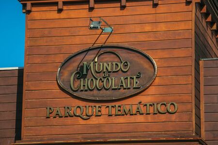 Gramado, Brazil - July 21, 2019. Signboard in the wooden facade of Chocolate World store in a sunny day at Gramado. A cute european-influenced town highly sought after by tourists.のeditorial素材