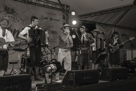 Canela, Brazil - July 21, 2019. Musicians wearing typical clothes performing traditional songs in folkloric festival at Canela. A small town very popular by its ecotourism. Black and white photo.のeditorial素材
