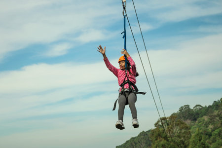 Canela, Brazil - July 21, 2019. Little girl descending by cables in a sport called zip-line over...