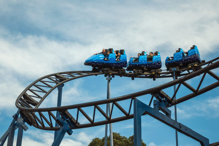 Canela, Brazil - July 21, 2019. People in a blue cart having fun on roller coaster in a cloudy day at the Alpen amusement park near Canela. A charming small town very popular by its ecotourism.のeditorial素材