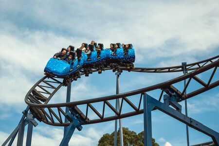 Canela, Brazil - July 21, 2019. People in a blue cart having fun on roller coaster in a cloudy day at the Alpen amusement park near Canela. A charming small town very popular by its ecotourism.のeditorial素材