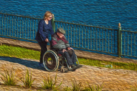 Gramado, Brazil - July 21, 2019. Woman pushing an elderly in wheelchair at the Joaquina Rita Bier Lake in Gramado. A cute european-influenced town highly sought after by tourists. Oil Paint filter.のeditorial素材