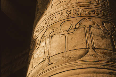 Column covered by hieroglyphics carved in bas-relief by the ancient Egyptians in a temple near Aswan. A village of enormous archaeological significance next to the Nile River in southern Egypt.の写真素材
