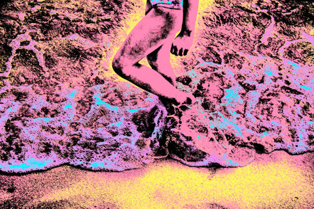 Child legs walking on sand with sea water on beach near Paraty, an historic town totally preserved...