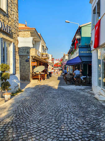 Tourists walking and sitting on the street of AlaÃ§atÄ±の写真素材