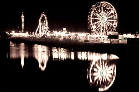 Night shot of a ferris wheel by the lakeの写真素材