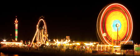 Night shot of a ferris wheel by the lakeの写真素材