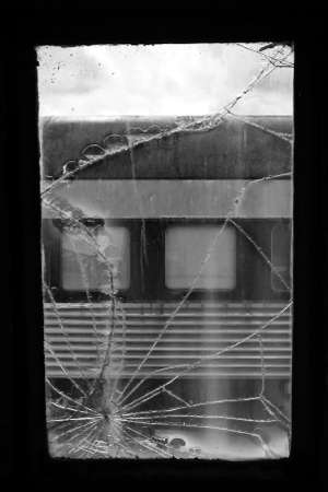 Detail of a broken window on a train.の写真素材