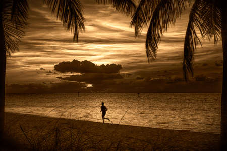 Silhouette of a person running on the beach at sunset, Key West, Monroe County, Florida, USAの写真素材