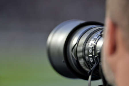 Photojournalist works with a 300mm telephoto lens in an external areaのeditorial素材