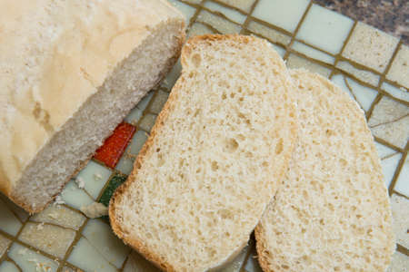 Slice of homemade bread on a tileの写真素材