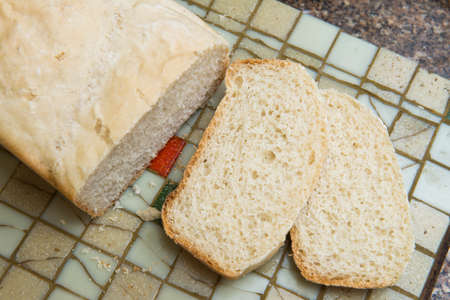 Slice of homemade bread on a tileの写真素材