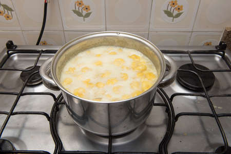sweet banana being cooked in a stainless steel pan in a sugar syrupの写真素材