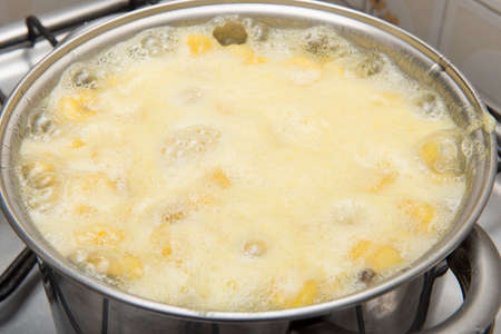 sweet banana being cooked in a stainless steel pan in a sugar syrupの写真素材