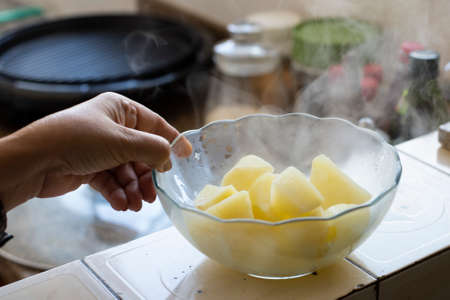 person holding a can of hot potatoes, coming out smoke.の写真素材