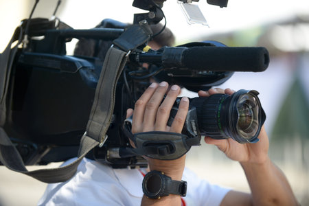 cameraman holding camera during interview on the street