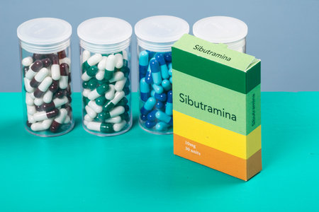 colored capsule of medication in transparent plastic storage container and obesity medicine box
