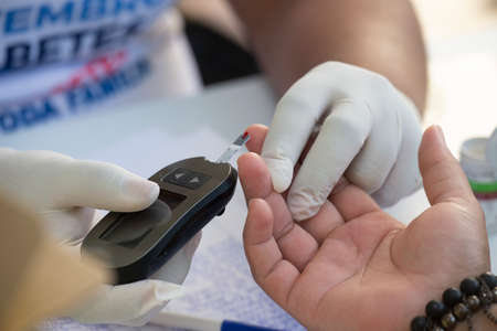 Rio de Janeiro, Brazil - november 22, 2018: Healthcare Professional Gets Fast Blood Glucose Testing during screening campaignのeditorial素材