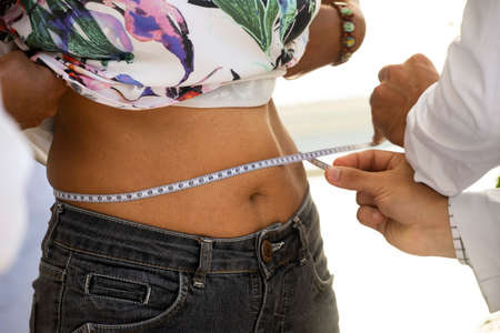 Rio de Janeiro, Brazil - november 22, 2018: health professional measuring a patient's waistのeditorial素材