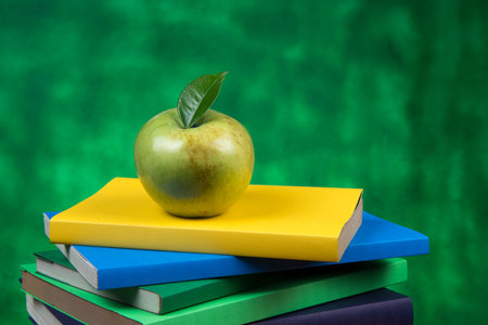 Green Apple fruit on top of a book stack, on the back of school classesの写真素材