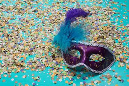 confetti spread on blue background with a female carnival mask.の写真素材
