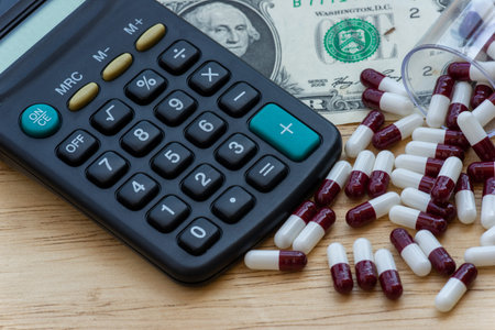 person making medical account, in a pocket calculator with a wooden backgroundの写真素材