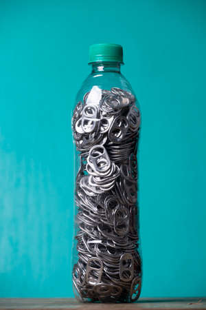 aluminum pull tabs inside plastic bottle to recicleの写真素材