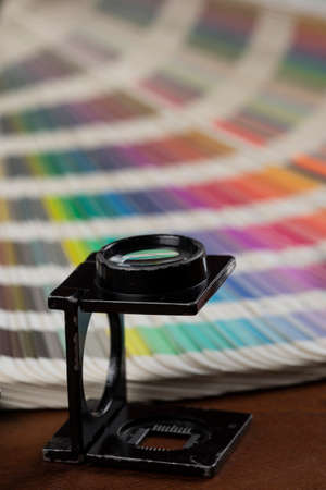 printed color swatch with a magnifying glass, cutter and paint brushの写真素材