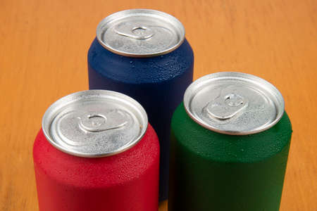 3 cold cans of soda in different colors with water dropsの写真素材