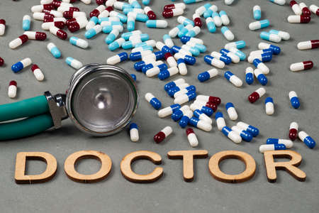 stethoscope and medicine blister on a slate floor  with de word Doctor writeの写真素材