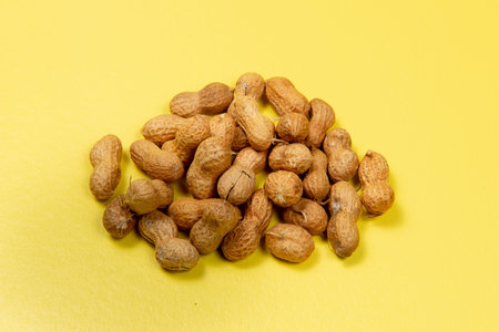 shelled peanuts on yellow background, Up view