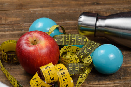 Weight control concept, with measure objects, and exercise weight, with an apple. Horizontal...