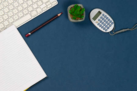 keyboard, calculator, pencil in a blue back groundの写真素材