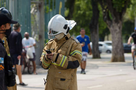 Rio, Brazil - september 28, 2020: fireman man makes notes on his cell phoneのeditorial素材