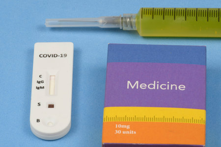 rapid coronavirus test with syringe yellow liquid and a medicine box