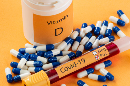 Vitamin D container with capsules around it and a vacuum tube with the text Covid-19
