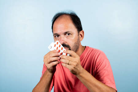 Portrait of mature man standing on blue background.の写真素材