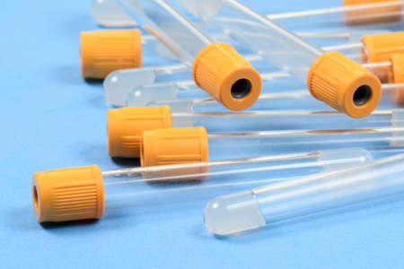 empty vacuum tube for blood collection on blue background.の写真素材