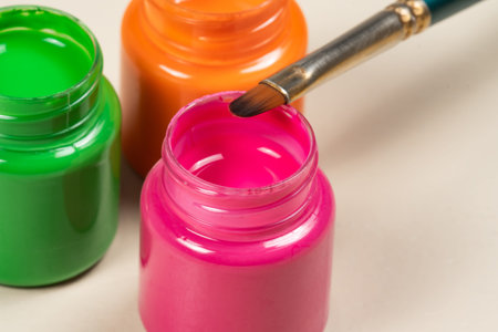 Open gouache paint glass opened on whiteの写真素材