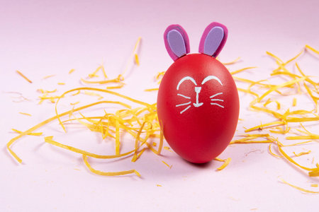 egg with easter rabbit drawn on pink background