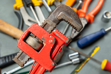 Griffin wrench isolated on blurred background with a variety of tools.