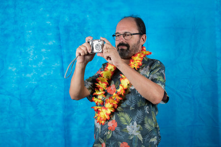 person dressed as a tourist with printed shirt and photo camera in handの写真素材