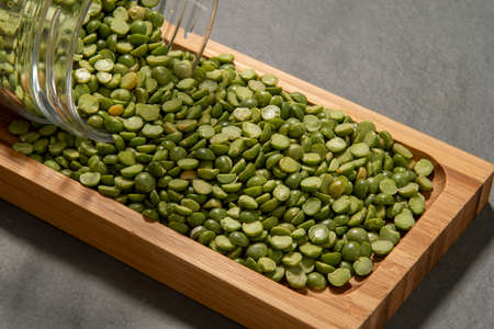 glass pot with dried peas in halves pouring outの写真素材