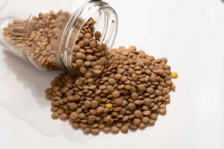 glass jar with fallen lentil seed and pile outsideの写真素材