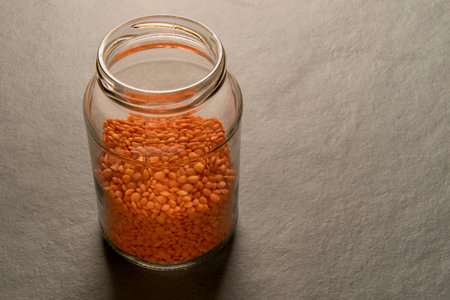 Lentils in a glass jar isolated on a gray table