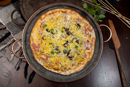 Brazilian Portuguese-style pizza with ham, egg, pepper, onion, mozzarella, top viewの写真素材